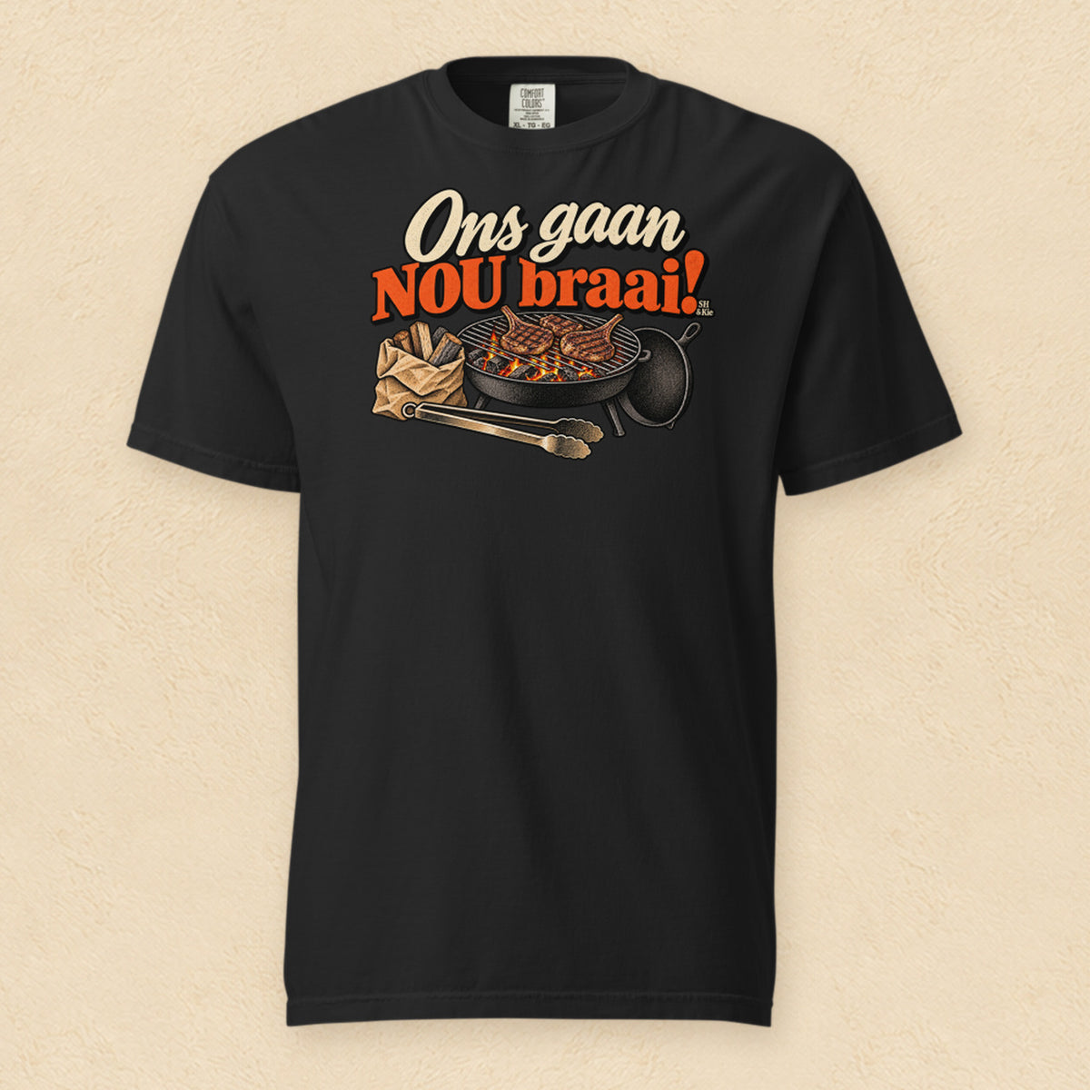 Ons gaan nou braai! — Black shirt on cream wall